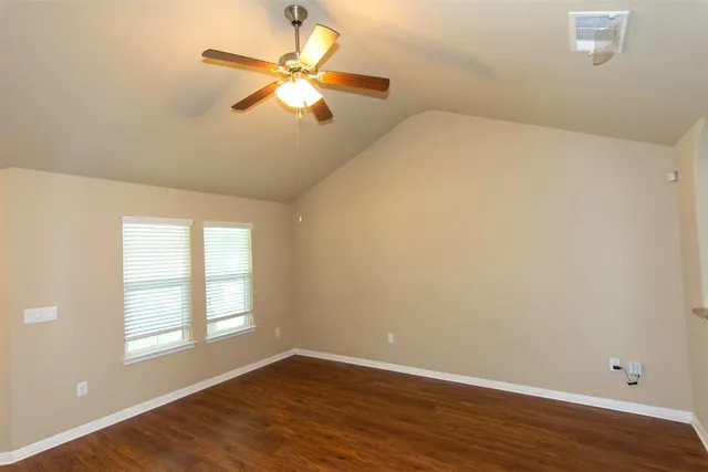 a view of a livingroom with a chandelier fan and wooden floor