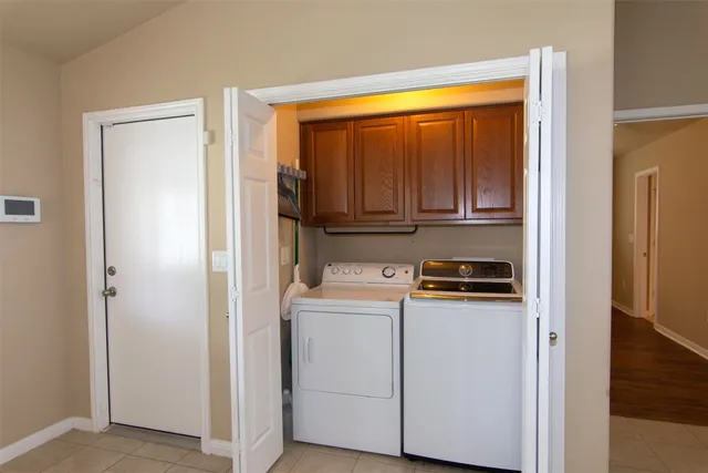 a view of a backyard with potted plants and large trees