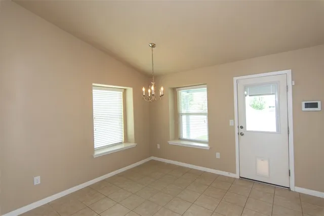 an empty room with wooden floor and fan