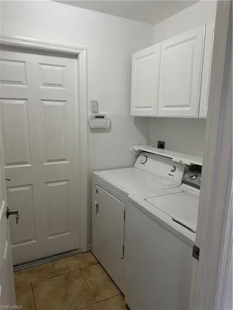 a utility room with cabinets washer and dryer