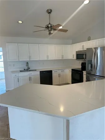 a large kitchen with stainless steel appliances a stove a refrigerator a sink dishwasher a stove top oven a refrigerator and cabinets