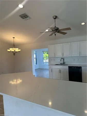 a view of a kitchen with a sink and chandelier