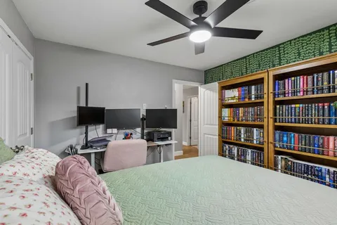 a bedroom with a bed furniture and a book shelf
