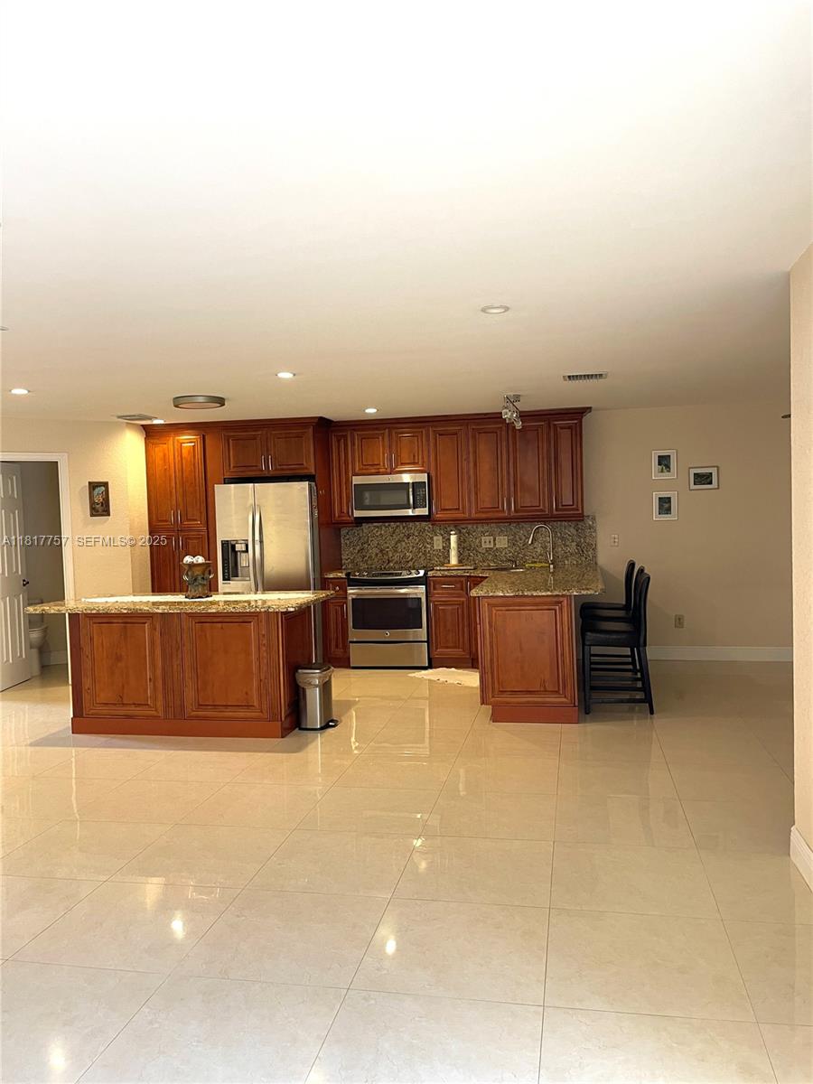 10290 Southwest 139th Court Miami, FL 33186 - Photo 15 of 66 a kitchen with stainless steel appliances a refrigerator and a stove top oven