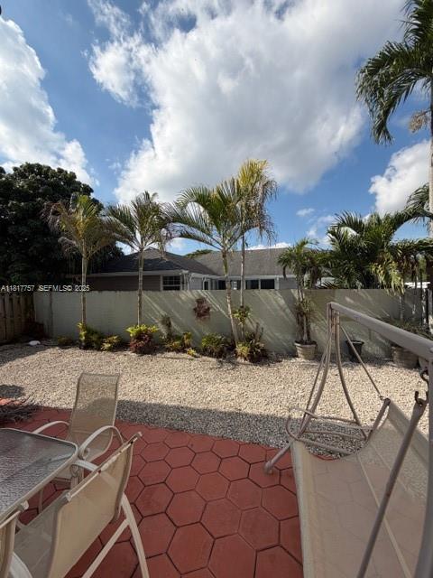 10290 Southwest 139th Court Miami, FL 33186 - Photo 52 of 66 a view of a patio with table and chairs with wooden fence