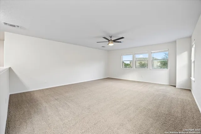 a view of a livingroom with a ceiling fan and window