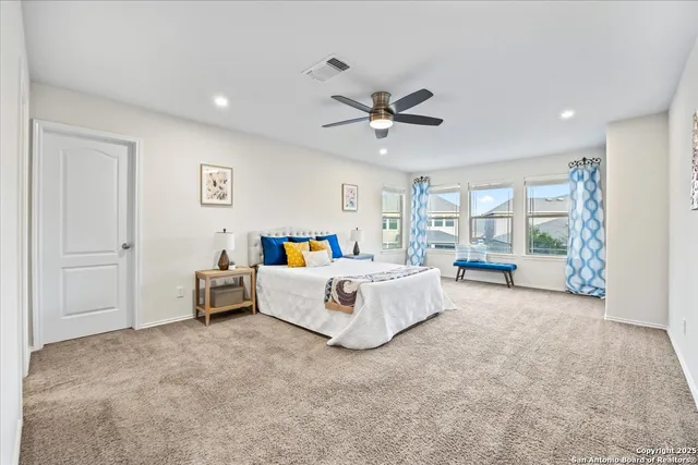 a spacious bedroom with a bed and a chandelier