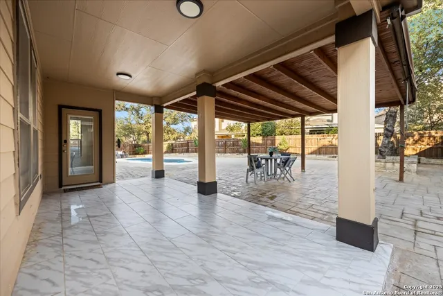 a view of a porch with chairs and backyard of a house