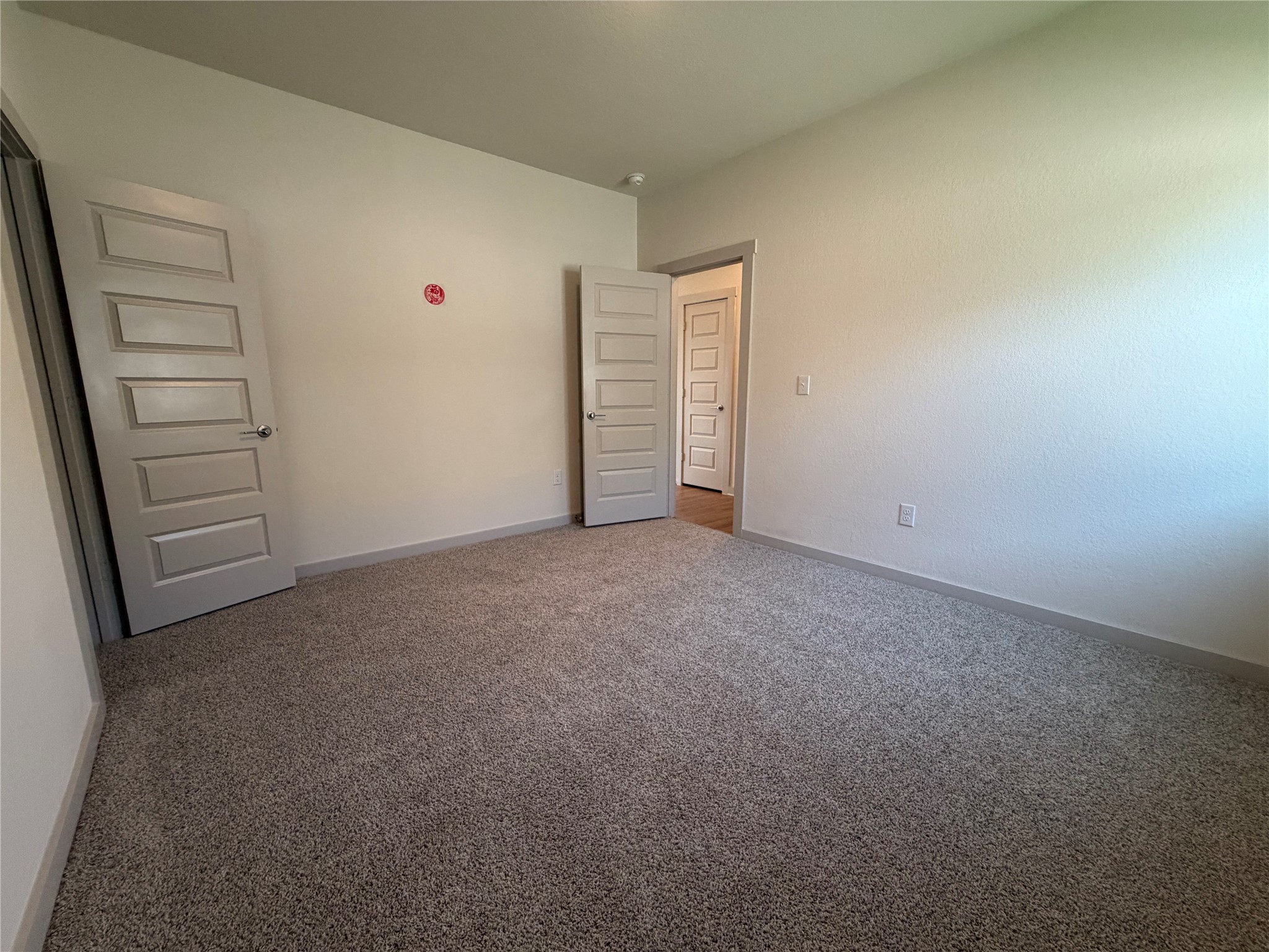 10708 Gonzales Ranger Pass Austin, TX 78754 - Photo 23 of 40 A spacious, naturally illuminated room featuring plush carpet and elegant paneled doors.