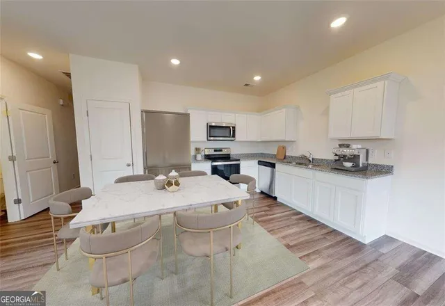 a large white kitchen with kitchen island a sink a stove and white cabinets