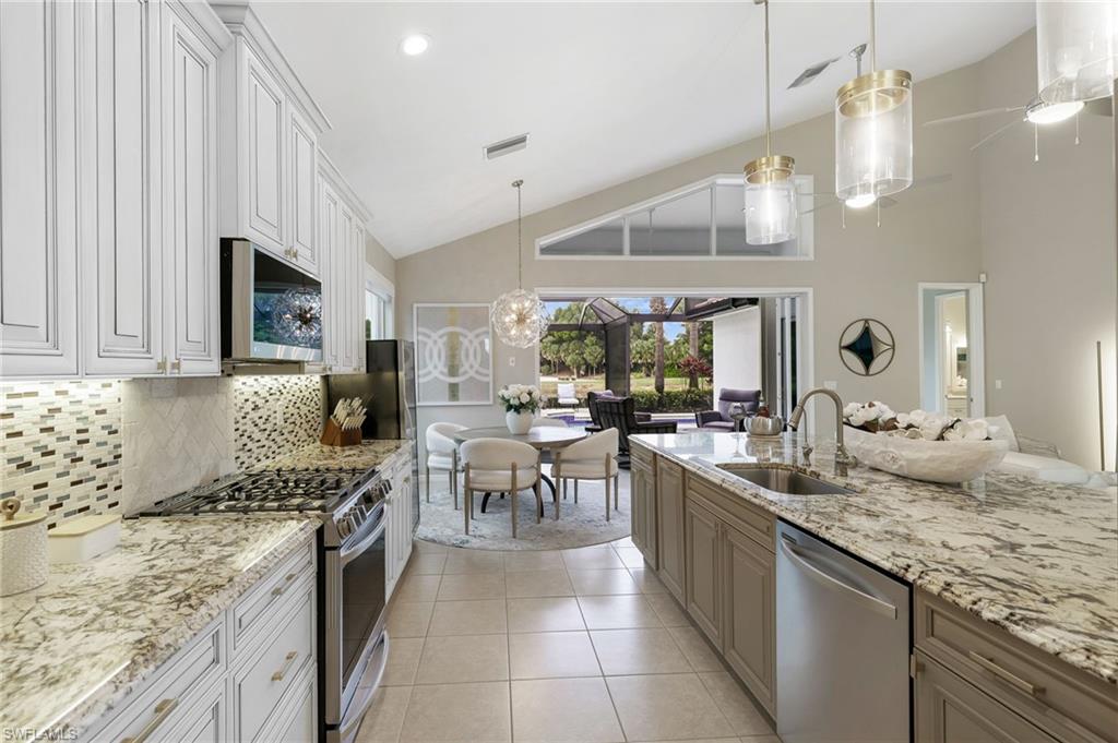 17959 Modena Road Miromar Lakes, FL 33913 - Photo 12 of 48 a kitchen with stainless steel appliances granite countertop a sink stove and cabinets