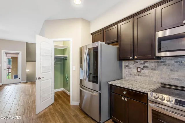 a kitchen with granite countertop stainless steel appliances and wooden cabinets