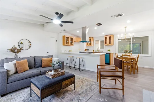 a living room with furniture kitchen view and a large window