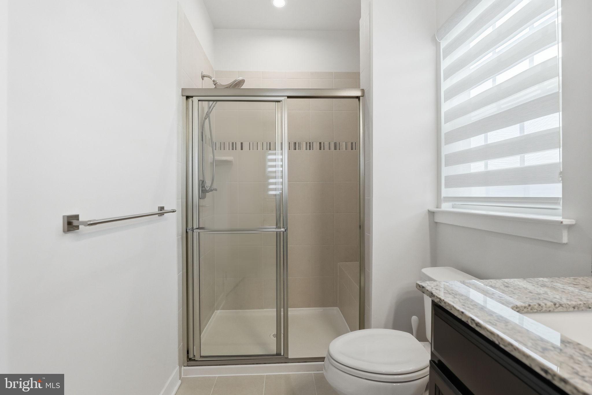 18112 Red Cedar Road Dumfries, VA 22026 - Photo 26 of 69 a bathroom with a granite countertop sink toilet and shower