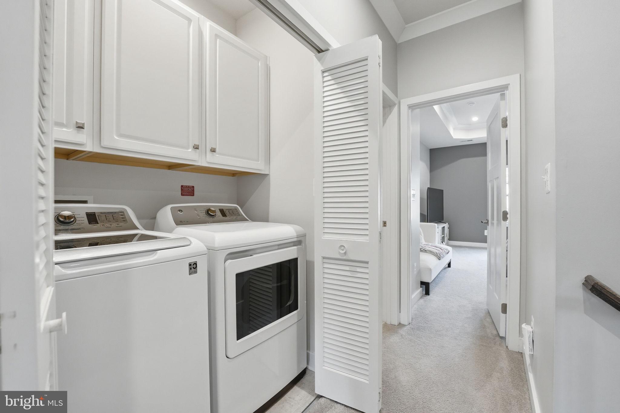 18112 Red Cedar Road Dumfries, VA 22026 - Photo 31 of 69 a view of washer and dryer with kitchen in the background