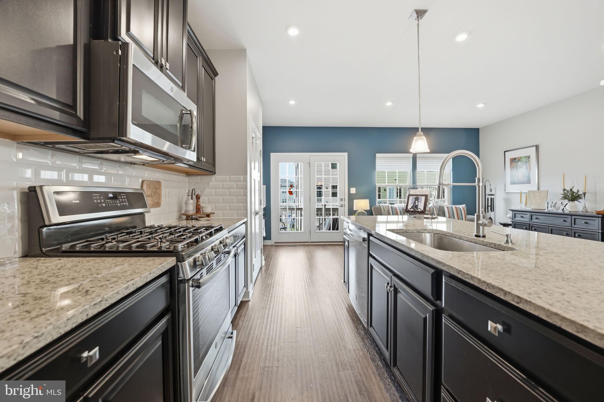 18112 Red Cedar Road Dumfries, VA 22026 - Photo 7 of 69 a kitchen with stainless steel appliances granite countertop a stove a sink and a microwave