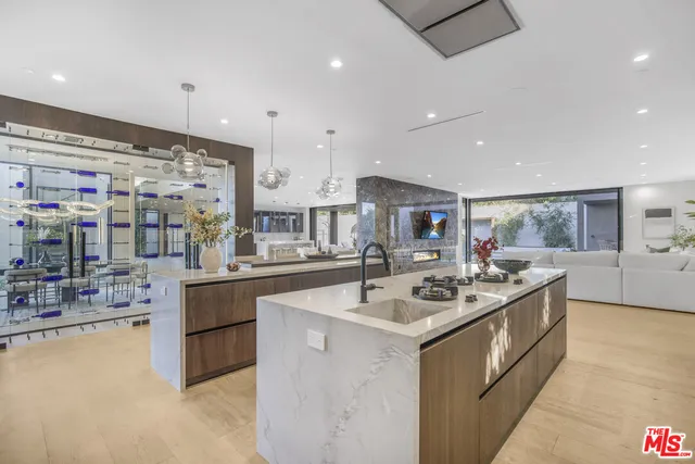 a kitchen with stainless steel appliances a stove a sink a oven and white cabinets with wooden floor