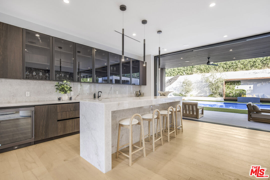 4246 Levitt Lane Sherman Oaks, CA 91403 - Photo 18 of 63 a kitchen with stainless steel appliances granite countertop a stove a sink a oven a dining table and chairs with wooden floor