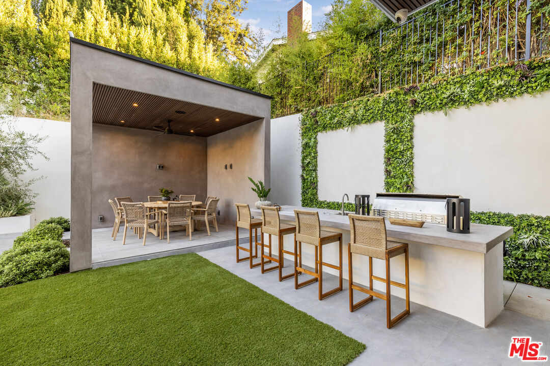 4246 Levitt Lane Sherman Oaks, CA 91403 - Photo 57 of 63 a view of a patio with table and chairs and potted plants with wooden fence