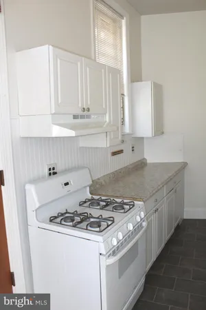 a stove top oven sitting inside of a kitchen