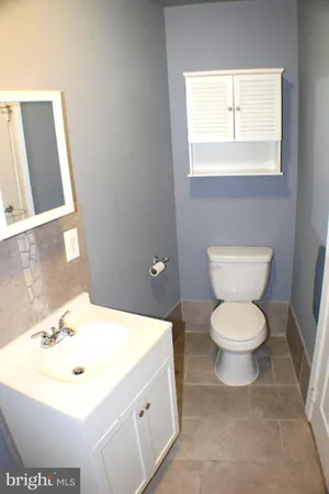 a bathroom with a toilet sink and mirror