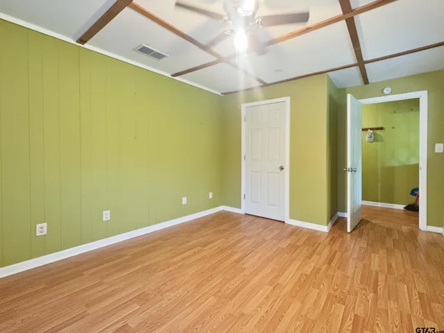 a view of a big room with wooden floor and windows
