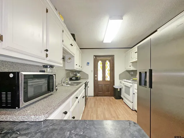 a large kitchen with a stove and a refrigerator