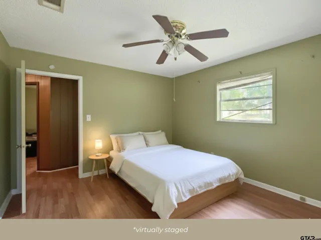 a bedroom with a bed and wooden floor