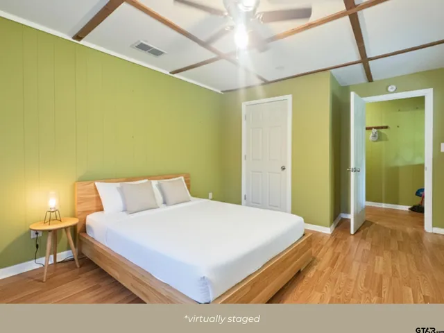 a bedroom with a bed and a wooden floor