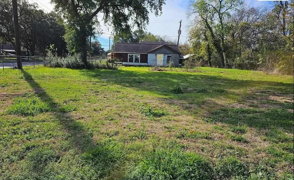 a view of a house with a big yard and large trees