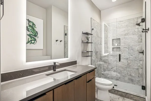 a bathroom with a sink a toilet and shower
