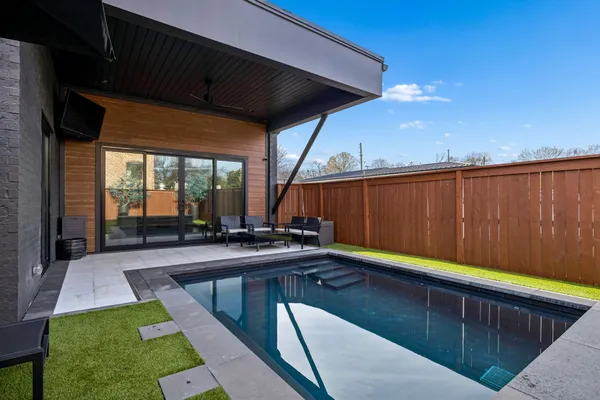 a swimming pool with outdoor seating and yard