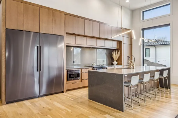 a kitchen with stainless steel appliances granite countertop a refrigerator a stove and a wooden cabinets