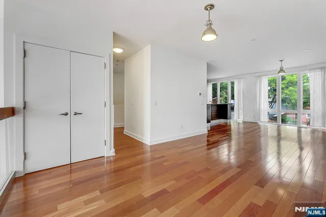 a view of a kitchen with wooden floor and a window