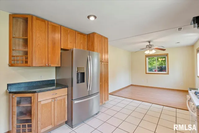 a kitchen with a refrigerator a stove top oven and cabinets