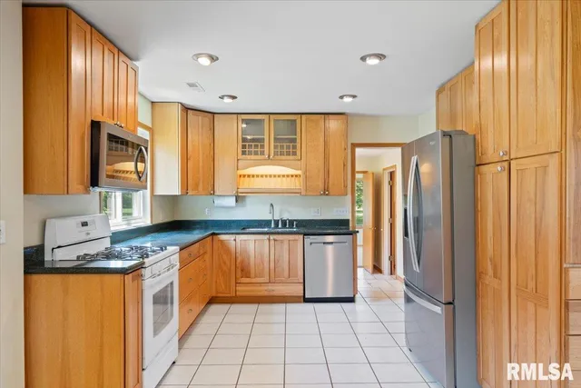 a kitchen with stainless steel appliances granite countertop a refrigerator and a sink