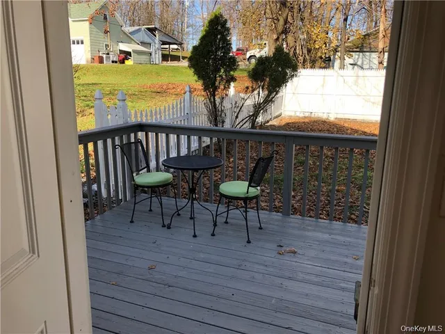 a view of a balcony with chairs and wooden floor