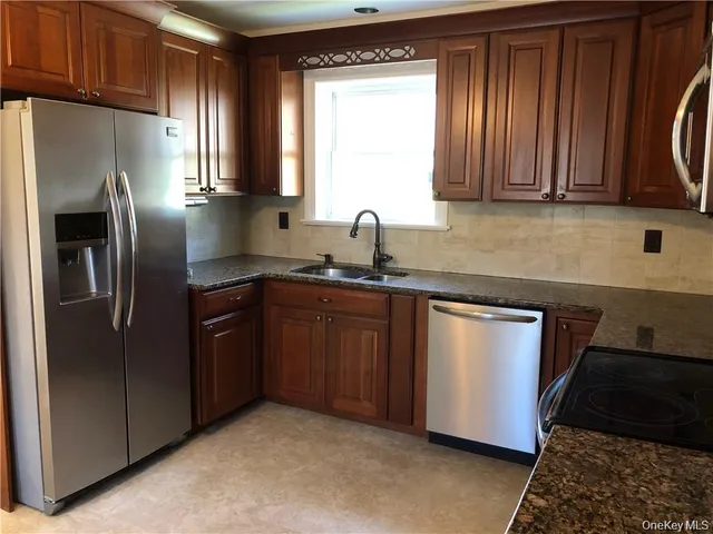 a kitchen with stainless steel appliances granite countertop a refrigerator a sink a stove a microwave and island