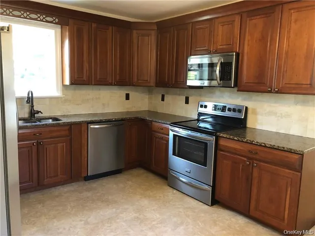 a kitchen with sink a microwave and cabinets