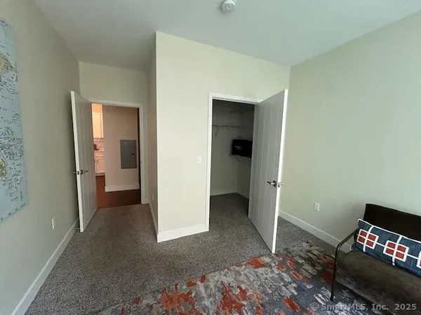 a view of a room that has a bed and a chair in it