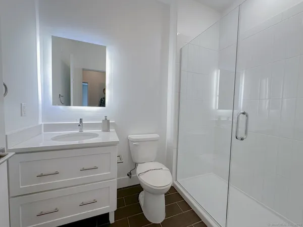 a bathroom with a toilet sink vanity and mirror