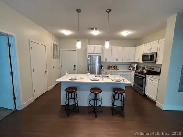 a kitchen with kitchen island stainless steel appliances a sink and a refrigerator