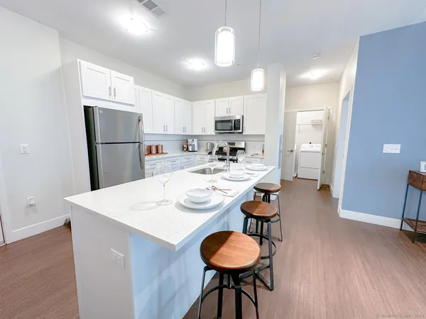 a kitchen with a dining table chairs refrigerator and cabinets