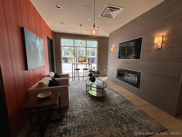 a living room with furniture a window and a flat screen tv