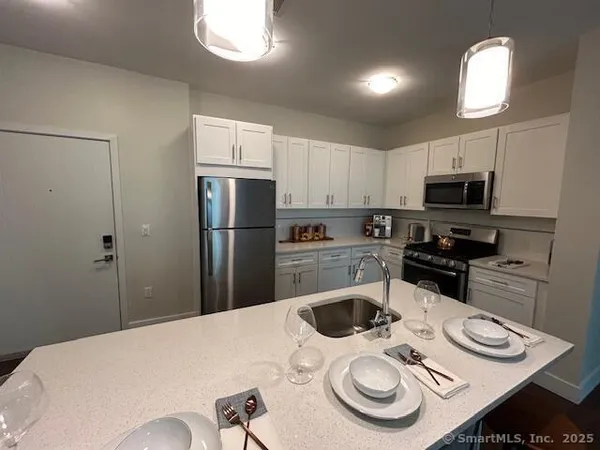 a kitchen with stainless steel appliances wooden floor dining table and chairs