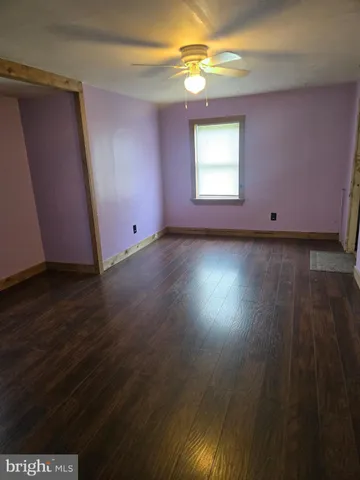 a view of a livingroom with wooden floor and window