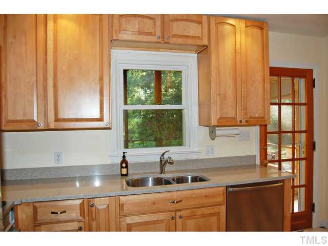 3317 Octavia Street Raleigh, NC 27606 - Photo 7 of 25 Cooking is a delight in the updated kitchen that offers stainless steel appliances, granite counters, large cabinets, checker tile floors, and a glass French door to the screened porch.