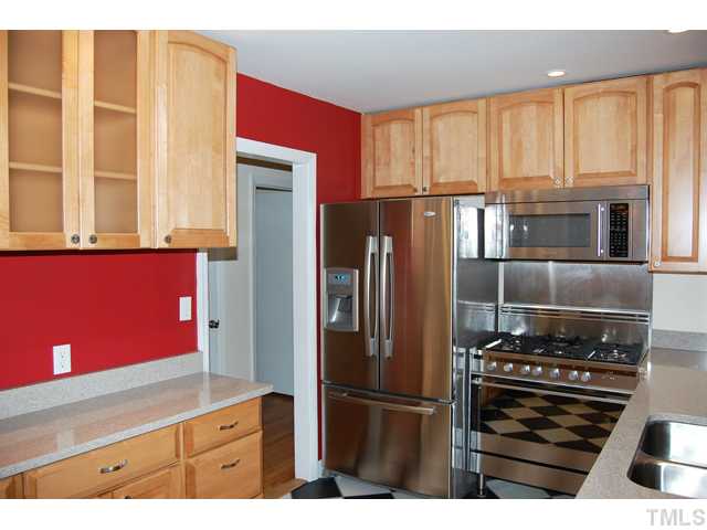 3317 Octavia Street Raleigh, NC 27606 - Photo 8 of 25 Cooking is a delight in the updated kitchen that offers stainless steel appliances, granite counters, large cabinets, checker tile floors, and a glass French door to the screened porch.