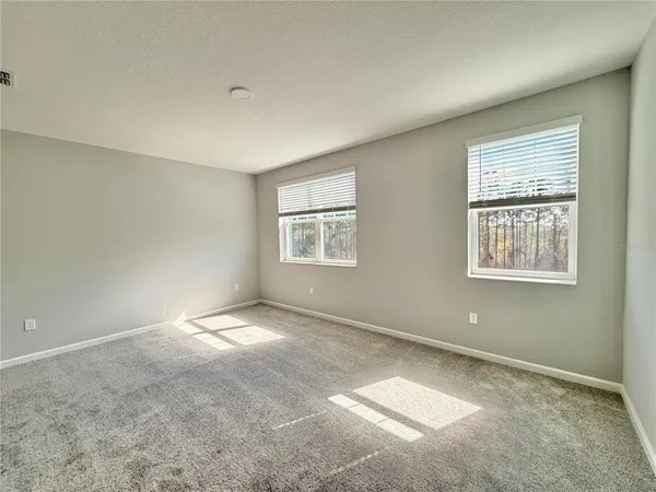 an empty room with windows and closet