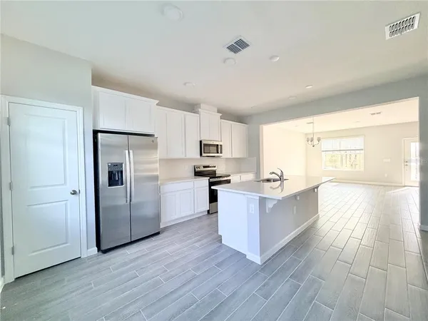 a kitchen with stainless steel appliances a refrigerator and a stove top oven